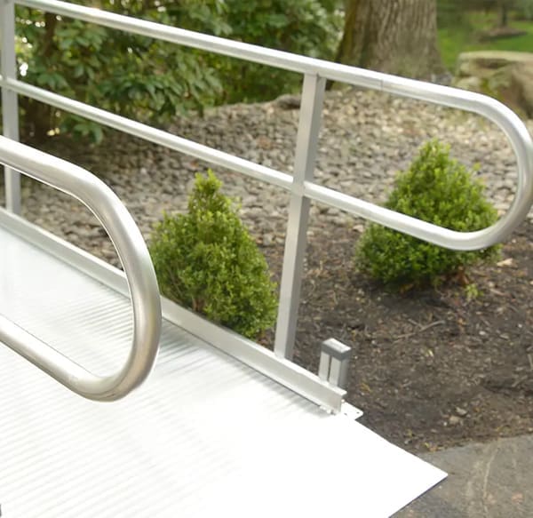 Aluminum wheelchair ramp with handrails installed at the front entrance of a home by Access Elevator, Inc.