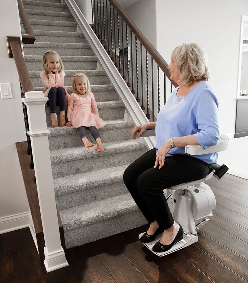 Elan-Straight-Indoor-Stair-Lift-08 Bruno Elon Straight Stairlift with Grandma on Lift and Two Granddaughters on Home Stairs