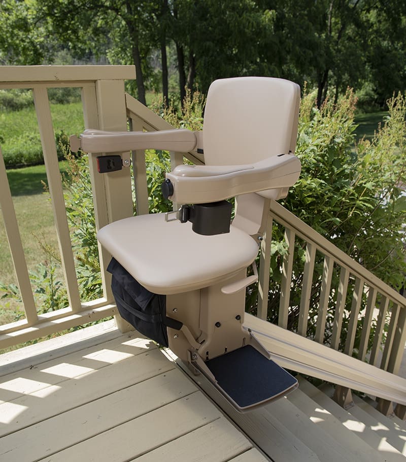 Bruno Elite Bariatric Straight Outdoor Stairlift at Top of Stairs on Wood Deck Swiveled Out Overlooking Lush Yard.
