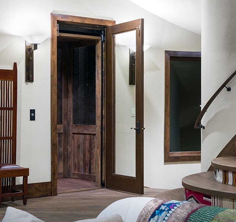 Residential elevator with glass doors and modern interior installed by Access Elevator, Inc.
