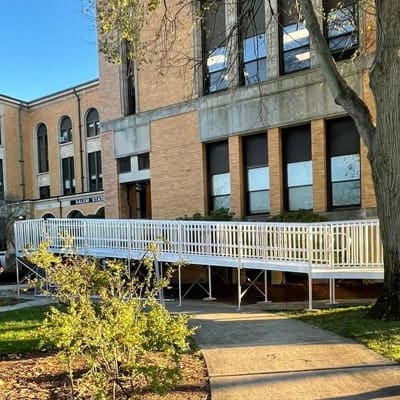 Aluminum Commercial Wheelchair Ramp from National Ramps Installed in front of brick building.